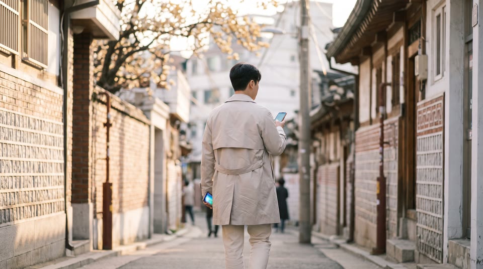 핸드폰으로 메시지를 보내며 걷고 있는 사람의 뒷모습