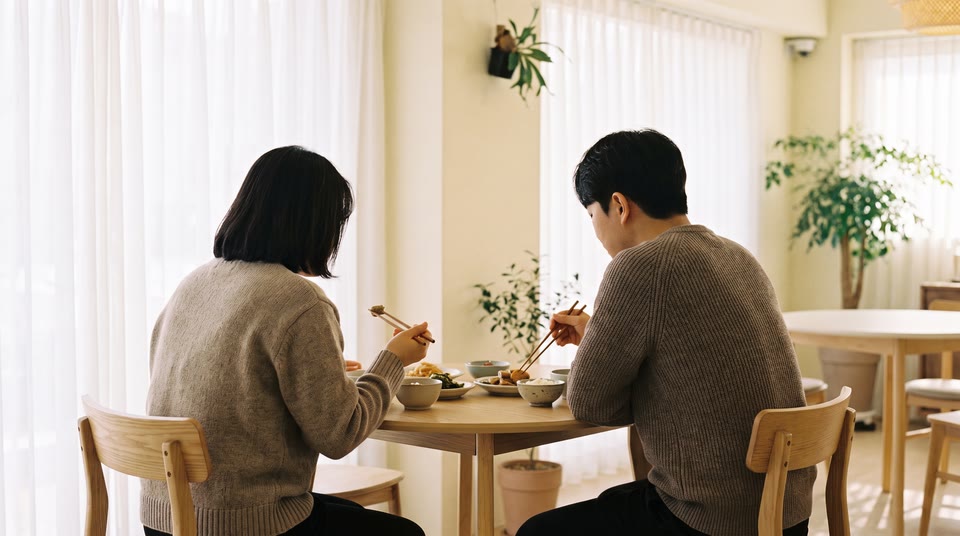 식당 테이블에 마주 앉아 밥을 먹는 두 사람